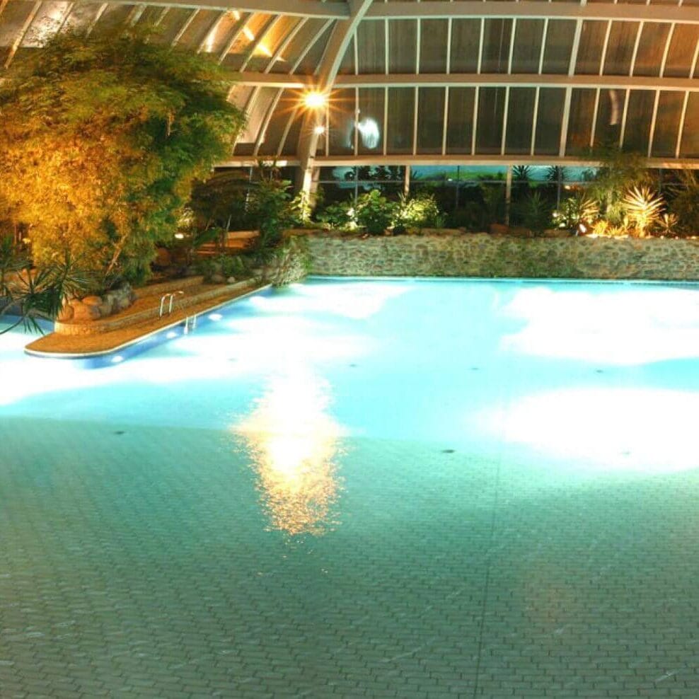 Tropische Badelandschaft mit Innenpool und üppiger Begrünung